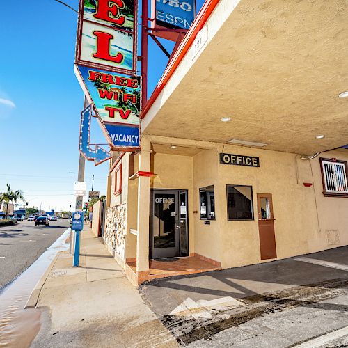 A roadside motel with a neon sign offering free WiFi and TV, displaying 